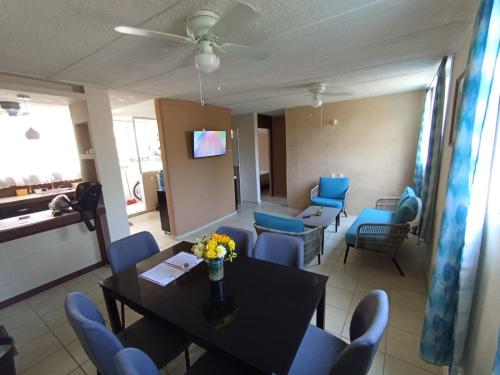 a living room with a table and blue chairs at Casa Ixtlán Planta Baja in Santa Cruz Huatulco