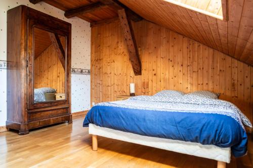 a bedroom with a bed in a room with wooden walls at Gite des Rousses d'Amont - 15 personnes in Les Rousses