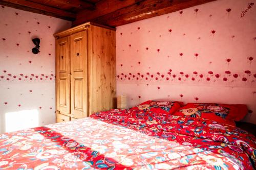 a bedroom with a bed with red hearts on the wall at Gite des Rousses d'Amont - 15 personnes in Les Rousses