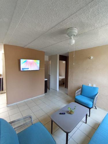 a living room with a couch and a table and a tv at Casa Ixtlán Planta Baja in Santa Cruz Huatulco
