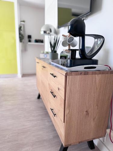 - une commode en bois avec une cafetière dans l'établissement Appartement bien situé réservation du samedi au samedi minimum, à La Teste-de-Buch