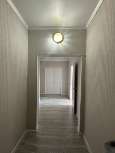 un pasillo vacío con una luz en el techo en Элитная 2-х комнатная квартира со всеми удобствами, en Shymkent