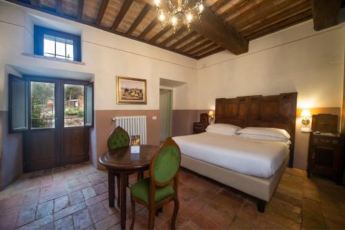 フォリーニョにあるLa Maestà antica dimora di campagnaのベッドルーム1室(ベッド1台、テーブル、椅子付)