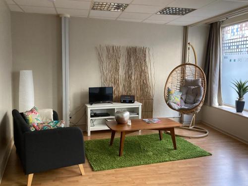 a living room with a coffee table and a chair at Gîte d'Avalon Appartement 5 in Dinant