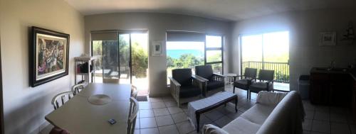 a living room with a couch and a balcony at Chandos Apartment Vleesbaai in Vleesbaai