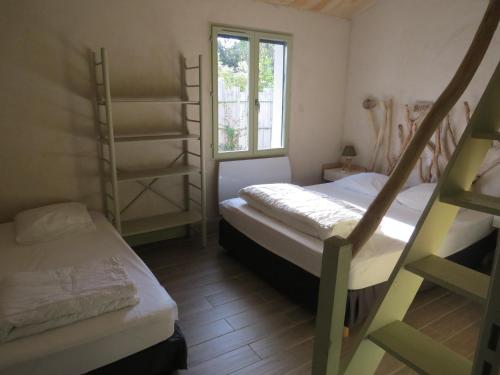 a room with two bunk beds and a window at La Belle Insulaire à Vert Bois in Dolus-d'Oléron