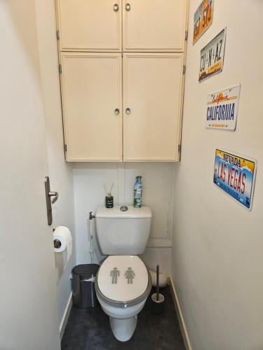 een badkamer met een wit toilet en een kast erboven bij Beautiful & cosy apartment - La Défense in Courbevoie