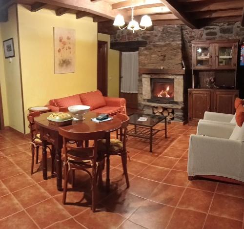 sala de estar con mesa y chimenea en Apartamentos rurales Casa Xepo, en Rengos