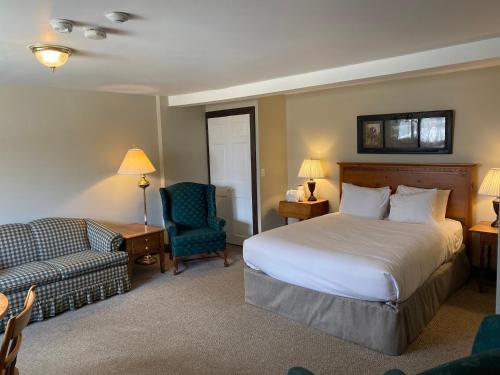 ein Hotelzimmer mit einem Bett und einem Stuhl in der Unterkunft The Wildflower Inn in Lyndonville