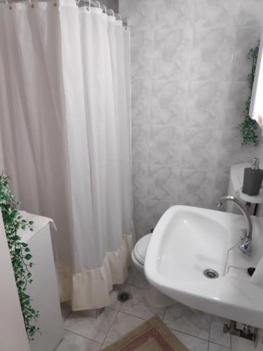 a bathroom with a white shower curtain and a sink at Mary's Home in Kalamata