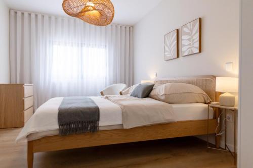 a bedroom with a large bed and a window at Blue House- am Strand von Vila do Conde, Porto in Vila do Conde