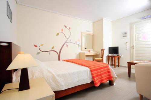 um quarto com uma cama com um mural de árvore na parede em Petrokalli Houses em Kálamos Kythira