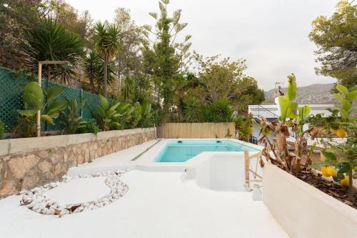 una piscina en medio de un jardín en Villa glamur en Les Botigues de Sitges 