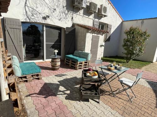 een patio met een tafel en stoelen op een bakstenen patio bij ARLES CAMPAGNE LOCATION "La Campagn'Arles" in Arles
