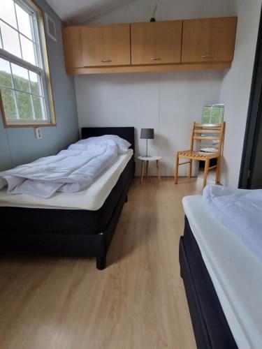 - une chambre avec deux lits, une chaise et une fenêtre dans l'établissement Kustverhuur, Groede, Paarlhof 17, à Groede