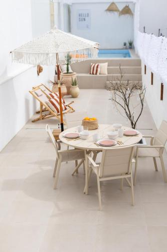 a white room with a table and chairs and an umbrella at Blue House- am Strand von Vila do Conde, Porto in Vila do Conde