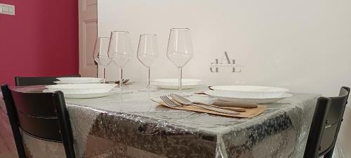 una mesa con platos y copas de vino. en de Lucia Affittacamere - Elegante appartamento storico nel cuore della città, en Terlizzi