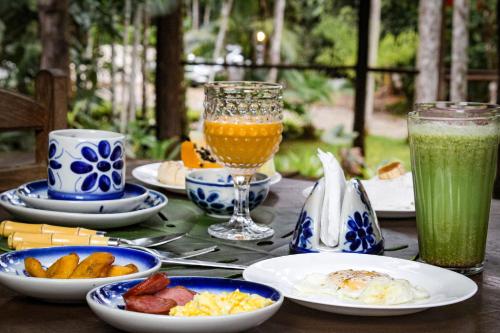 uma mesa coberta com pratos de alimentos e bebidas em Glamping Mangarito em Iporanga