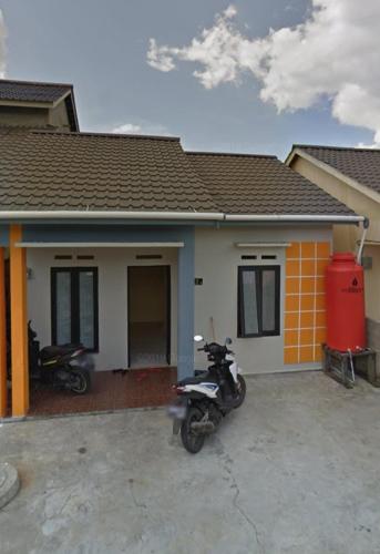 Sintia House في Sungaidurian: دراجة نارية متوقفة أمام منزل