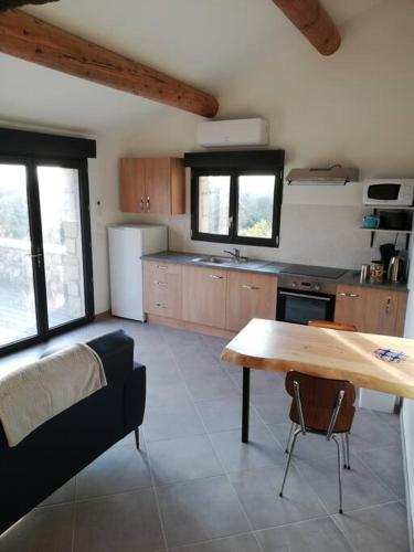 - une cuisine avec une table et un canapé dans l'établissement L'oustalou, à Saint-Genest-de-Bauzon