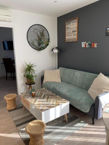 - un salon avec un canapé vert et une table basse dans l'établissement Appartement bien situé réservation du samedi au samedi minimum, à La Teste-de-Buch