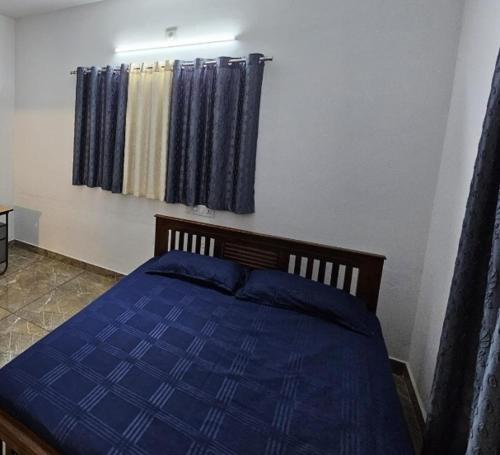 1 dormitorio con 1 cama azul con sábanas azules en Greenstay, en Idukki