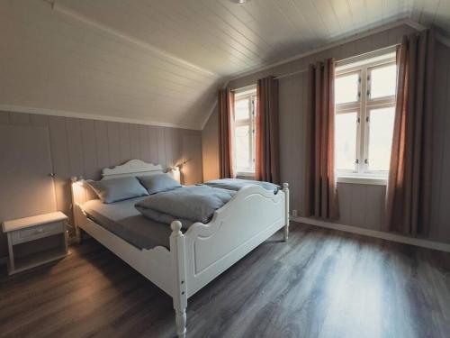 a bedroom with a white bed and a window at Hagusane Feriehus in Lærdalsøyri