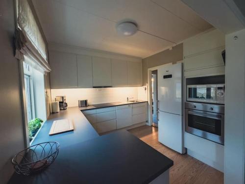 a kitchen with white cabinets and a black counter top at Hagusane Feriehus in Lærdalsøyri