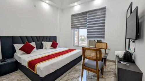 a bedroom with a bed and a desk and a television at HOTEL GREEN VEGAS in New Delhi