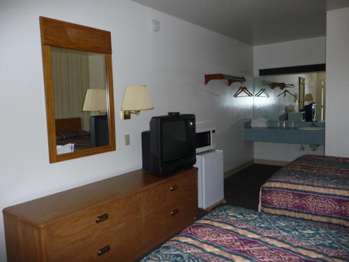 a hotel room with a bed and a tv on a dresser at Red Rose Motel in Elizabethtown