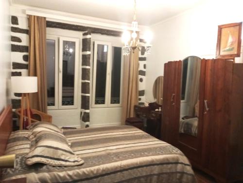 Schlafzimmer mit einem Bett und einem Fenster in der Unterkunft Arruda´s House in Ponta Delgada