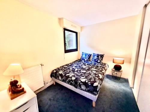 ein kleines Schlafzimmer mit einem Bett und einem Fenster in der Unterkunft Superbe appartement terrasse in Levallois-Perret