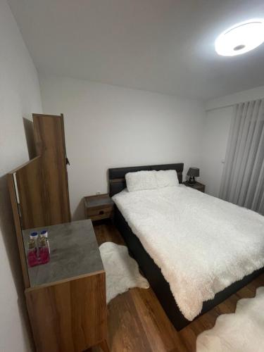 Luxury Apartment في Gnjilane: غرفة نوم فيها سرير وطاولة فيها