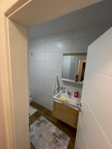Luxury Apartment في Gnjilane: حمام مع حوض ومرآة