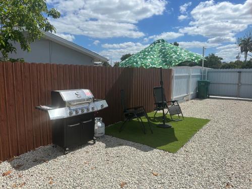 a backyard with a grill and a chair and a fence at Green planet in Naples