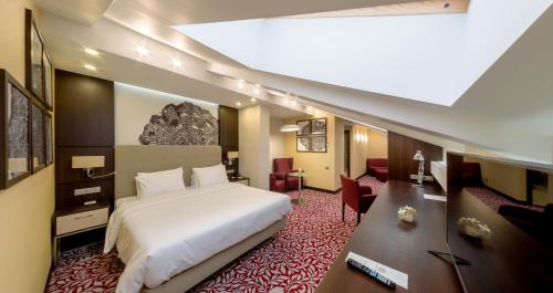 ウファにあるBashkiria Hotelのベッドルーム(白い大型ベッド1台、デスク付)
