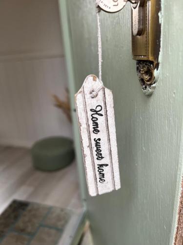 una etiqueta en la puerta de una habitación en Gehele accommodatie met boshuisje en 3 woonwagens, en Ranst