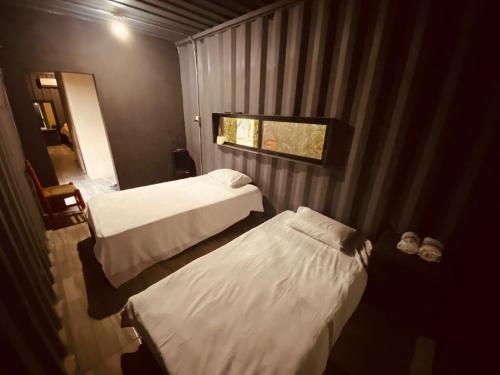 um pequeno quarto com 2 camas e uma janela em Container Manglar House em Nautla