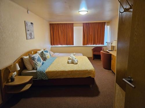 una habitación de hotel con una cama con un osito de peluche. en Auberge Bleech, en Larochette