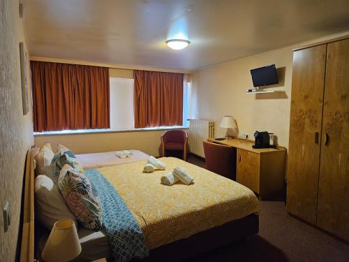 a hotel room with a bed and a desk at Auberge Bleech in Larochette