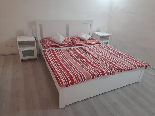 ein weißes Bett mit roter und weißer Bettwäsche und Kissen in der Unterkunft U Pichlerů in Klipec