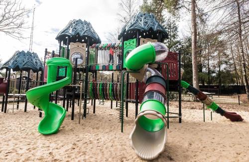 a playground in a park with a slide at Chalet de Bosrand 404, unieke rustige plek met veel privacy aan de bosrand van vakantiepark op de Veluwe in Beekbergen