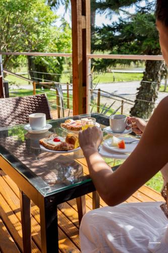 a person sitting at a table with food on it at Eco Hotel Oceanomare in Florianópolis