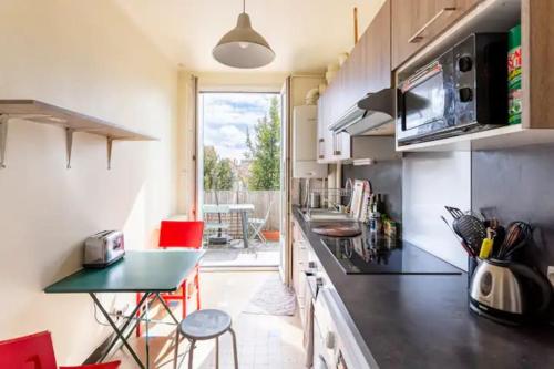 une cuisine avec un comptoir et une table avec des chaises dans l'établissement Logement 3 pièces à 10 minutes de Paris, aéroport, à Choisy-le-Roi