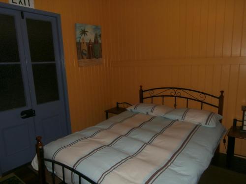 a bed in a room with a blue wall at Mango tourist Hostel in Hervey Bay