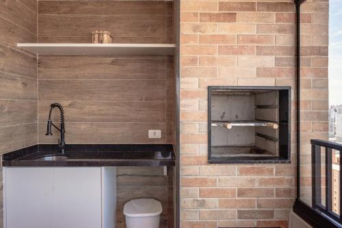 La salle de bains est pourvue d'un lavabo et d'un mur en briques. dans l'établissement Incrível resort paradisíaco!, à São Paulo