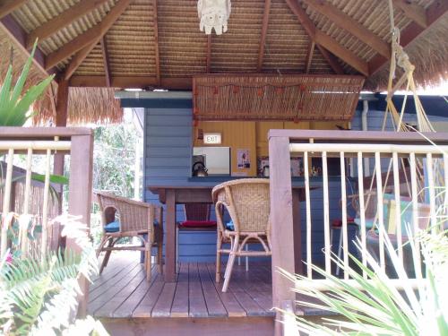 Mango tourist Hostel في خليج هيرفي: شرفة منزل مع طاولة وكراسي