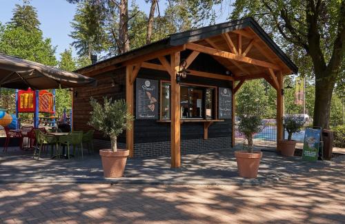 a small building with a bar in a park at Chalet de Bosrand 404, unieke rustige plek met veel privacy aan de bosrand van vakantiepark op de Veluwe in Beekbergen