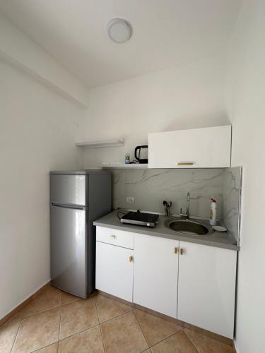 a small kitchen with a sink and a refrigerator at Evita's House in Lukovë