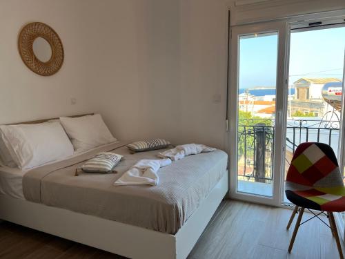a white bedroom with a bed and a balcony at "Calm Joy & J" - Infinity in Ermoupoli